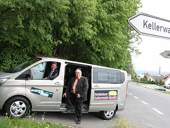 Alfred Fuchs (Geschäftsführer im Autohaus Thurn) am Steuer des Busses, der ab dem 20. Mai Gäste für einen Euro in den Kellerwald bringen wird. Rechts im Bild: Bürgermeister Franz Streit, der Ideengeber für den Shuttlebus. Foto: Ekkehard Roepert