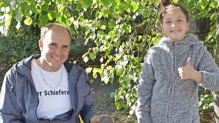 Der Schieferer lud die Kinder zum Mitmachen ein; Britta freut sich über das selbst geschlagene Herz.  Foto: Thomas Micheel