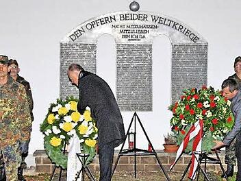 Bürgermeister Helmut Blank (links) und Stadtrat Burkard Schodorf (rechts) legten anlässlich des Volkstrauertages Kränze am Mahnmal auf dem Münnerstädter Friedhof nieder. Foto: Dieter Britz