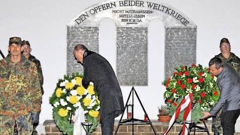 Bürgermeister Helmut Blank (links) und Stadtrat Burkard Schodorf (rechts) legten anlässlich des Volkstrauertages Kränze am Mahnmal auf dem Münnerstädter Friedhof nieder. Foto: Dieter Britz