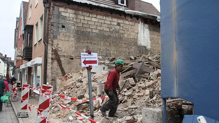 Erst als die Gebäudetrümmer komplett am Boden liegt, kann die Abbruchfirma Wasser einsetzen, um die Staubentwicklung zu reduzieren. Foto: Stephan Tiroch