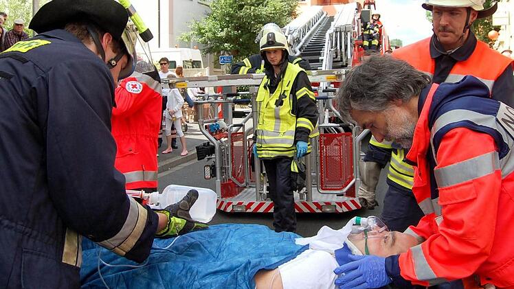 Notarzt Ralph Brath (rechts) kümmert sich bei der Rettungsübung ein letztes Mal um den Verletzten, bevor er mit dem Rettungswagen ins Krankenhaus gebracht wird.