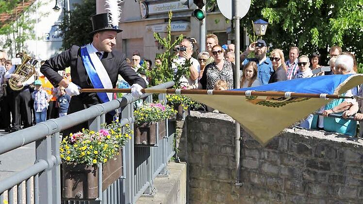 Der jüngste Stadtrat Sven Hofmann beim traditionellen Fahnenschwenken auf der Schwedenbrücke.  Fotos: Michael Wunder