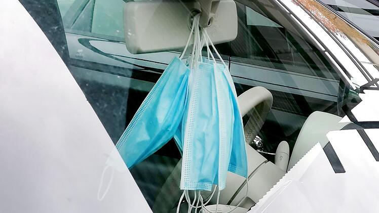 Die Maske schützt:  Zu den verschärften Vorgaben zur Eindämmung  der Corona-Pandemie zählt weiterhin die Maskenpflicht an bestimmten Orten.  In diesem Auto in Haßfurt hängen neue Masken griffbereit am Spiegel. Ren                 b Ruprecht