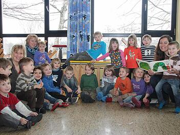 Die Kinder des Kindergartens in Grub am Forst lauschen Yvonne Rose (rechts) und der kleinen Raupe Nimmersatt.  Fotos: Thomas Heuchling