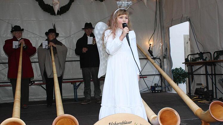 Das Münnerstädter Engelchen (Jule Klicha) eröffnete den Weihnachtsmarkt im Kreise der Alphörner.  Foto: Arnold Nöth