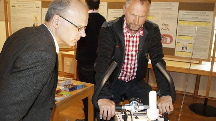Viel zu tun hatte beim "Tag der offenen Tür" im Umweltbildungszentrum der Energieberater Gunter Heckner (links). Sehr greifbar macht das Thema Elektrizität das Energiefahrrad, auf dem hier Stefan Hornung strampelt. Hier zeigt sich, welches Leuchtmittel mit der geringsten Anstrengung "anspringt".