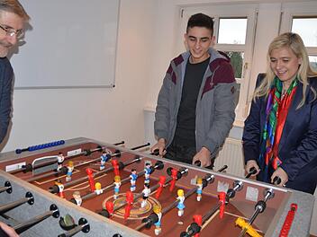 Mohammad Matin (Mitte) probiert mit Staatsministerin Melanie Huml und Landrat Michael Busch den Kicker aus, der im Hobbyraum der Wohngruppe in Tambach aufgestellt ist.Rainer Lutz