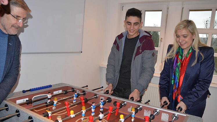 Mohammad Matin (Mitte) probiert mit Staatsministerin Melanie Huml und Landrat Michael Busch den Kicker aus, der im Hobbyraum der Wohngruppe in Tambach aufgestellt ist.Rainer Lutz