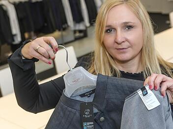 Greiff-Mitarbeiterin Nicole Wagner zeigt eine Jacke für Köche mit dem Fairtrade-Siegel. Foto: Barbara Herbst