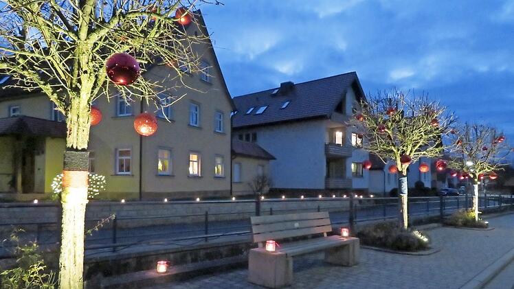 Adventsschmuck einmal anders: Die Bäume gegenüber der Kirche zeigen Flagge und stehen für Gemeinsamkeit. Foto: Monika Schütz