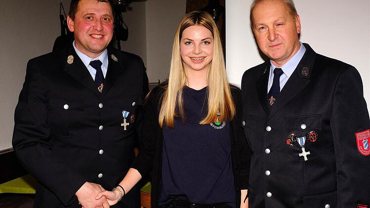 Kommandant Edgar Sitzmann (links) begrüßte mit dem traditionellen Handschlag Antonia Günther als neues Mitglied in der Wehr. Darüber freute sich auch Vorsitzender Detlef Heim. Foto: Gerd Schaar