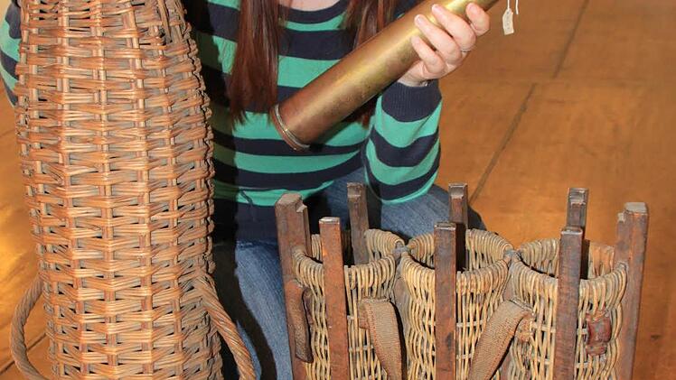 Ariane Schmiedmann vom Deutschen Korbmuseum in Michelau zeigt einige der Exponate - Geschosskörbe der verschiedenen Größen und eine Artilleriegranate, für deren sicheren Transport die Körbe bestimmt waren. Foto: Matthias Einwag