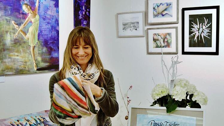 Inhaberin Uta Berg mit einem ihrer kunstvollen Poesie-Tücher.  Foto: Sigismund von Dobschütz