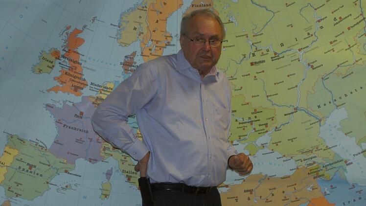Eduard Lintner vor einer Weltkarte, rechts unten liegt Aserbaidschan Karin Nerche-Wolf