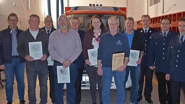 Die f&uuml;r langj&auml;hrige Vereinszugeh&ouml;rigkeit geehrten Mitglieder sowie der zum Ehrenmitglied ernannte Bernhard Scherer (5. v. r.) freuen sich mit Kommandant Florian Schwalme (5. v. l.), Vorsitzendem Thomas Pfaff (r.) sowie KBM Tobias Winterbauer (3. v...