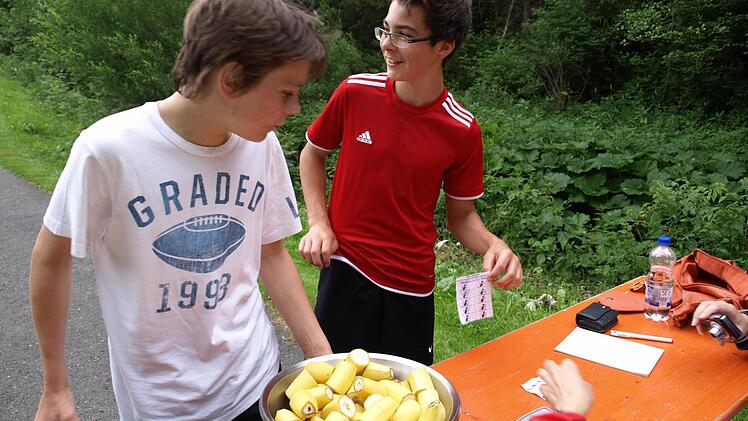 Felix Müller (r.) und Christopher Müller stärken sich beim Stempelpunkt mit frischem Obst.