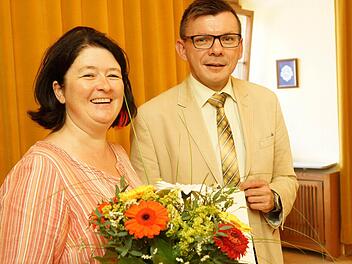 Bürgermeister Armin Warmuth gratuliert Silke Preyer mit einem Blumenstrauß zum Dienstjubiläum. Foto: Arkadius Guzy