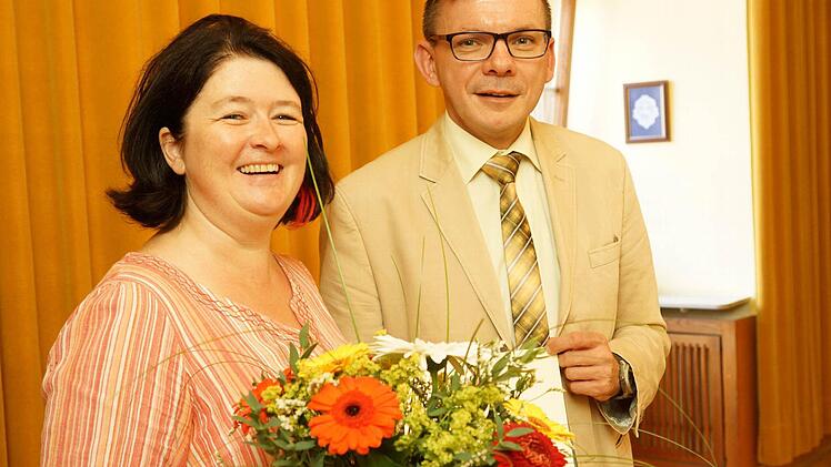 Bürgermeister Armin Warmuth gratuliert Silke Preyer mit einem Blumenstrauß zum Dienstjubiläum. Foto: Arkadius Guzy