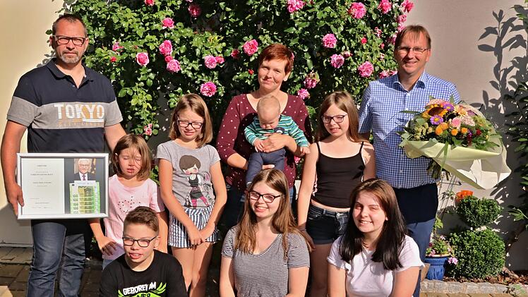 Bürgermeister Wolfram Thein (rechts) überbrachte die Glückwünsche der Gemeinde und die Ehrenpatenschaft von Bundespräsidenten Frank-Walter Steinmeier. Mit auf dem Foto (vorne von links): Emilio Marie, Lea und (hinten von links): Vater Alexander, Frieda, Mathilde, Mutter Marion mit Johann und Amalie.