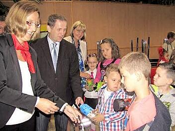 Sabrina Forkel von der Sparkasse, stellvertretender Landrat Rainer Mattern und Zweite Bürgermeisterin Birgit Weber (von links) verteilen die Emil-Flaschen an die Kinder. Foto: Martin Koch