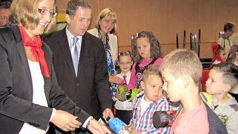 Sabrina Forkel von der Sparkasse, stellvertretender Landrat Rainer Mattern und Zweite Bürgermeisterin Birgit Weber (von links) verteilen die Emil-Flaschen an die Kinder. Foto: Martin Koch