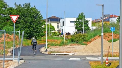 Diese Radlerin fährt auf dem neuen Radweg hinab zur Montrealstraße im Wohngebiet auf der Herzo Base.