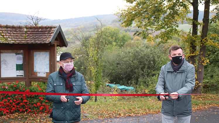 Stellvertretender Landra Gotthard Schlereth  (links) und Hammelburgs Bürgermeister Armin Warmuth gaben den neuen Wanderweg "Kalk und KulTOUR - Erleben in der Natur"  in Obereschenbach offiziell frei, indem sie ein rotes Band durchschnitten. Foto: Hilmar Ruppert