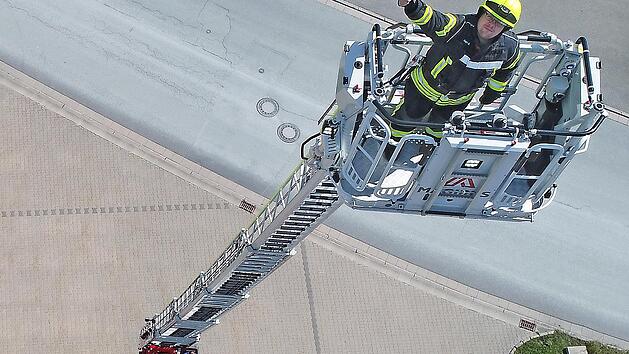 Luftiger Arbeitsplatz: Bis auf 32 Meter l&auml;sst sich die Drehleiter ausfahren. Sie kann vom Maschinisten, aber auch vom Korb aus bedient werden. Hier ist der Stadsteinacher Feuerwehr-Vorsitzende J&ouml;rg Geyer in luftiger H&ouml;he in Aktion.