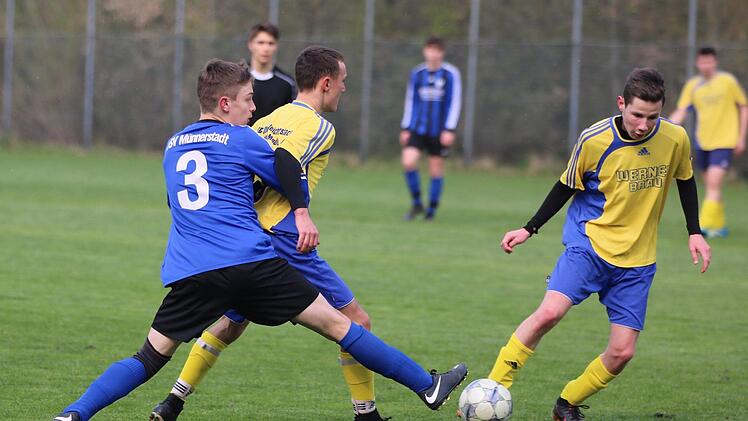 Mit Haltegriff und Grätsche: Münnerstadts U-19-Kicker Moritz Rittelmeier im Duell mit zwei Oberleichtersbachern.Sebastian Schmitt