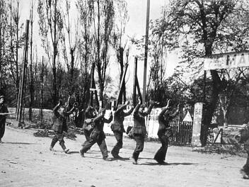 Deutsche Soldaten haben sich ergeben und werden von einem Amerikaner zu einem Sammelpunkt gebracht. Repro: Franze, aus: Karl Kunze "Kriegsende in Franken und der Kampf um Nürnberg"