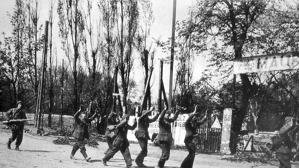 Deutsche Soldaten haben sich ergeben und werden von einem Amerikaner zu einem Sammelpunkt gebracht. Repro: Franze, aus: Karl Kunze "Kriegsende in Franken und der Kampf um Nürnberg"