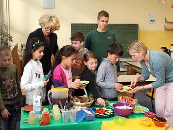 Adelinde Reinhardt, FSJler Felix Mitramescu und Andrea Homann (r.) helfen den Kindern bei der Auswahl und teilen auch aus. Foto: Johanna Blum