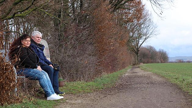 Blick in die Ferne: Andrea Leicht und Ottmar V&ouml;llner sitzen auf der Bank neben einem Gedenkstein f&uuml;r verstorbene Mitglieder, den der Verein aufgestellt hat. An guten Tagen k&ouml;nnen die beiden von hier aus bis nach N&uuml;rnberg sehen.Fotos: Yannick Hupfer