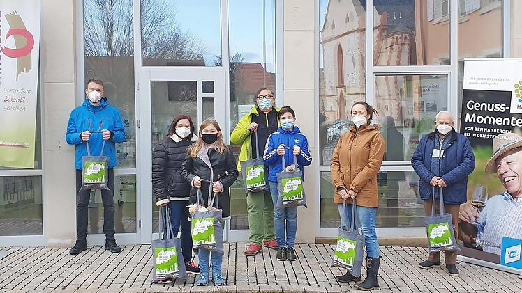 Die Gewinner der Fotoaktion "Ich lass‘ die Kohle im Dorf!" der Gemeinde-Allianz Hofheimer Land mit ihren Einkaufstaschen voller regionaler Produkte
