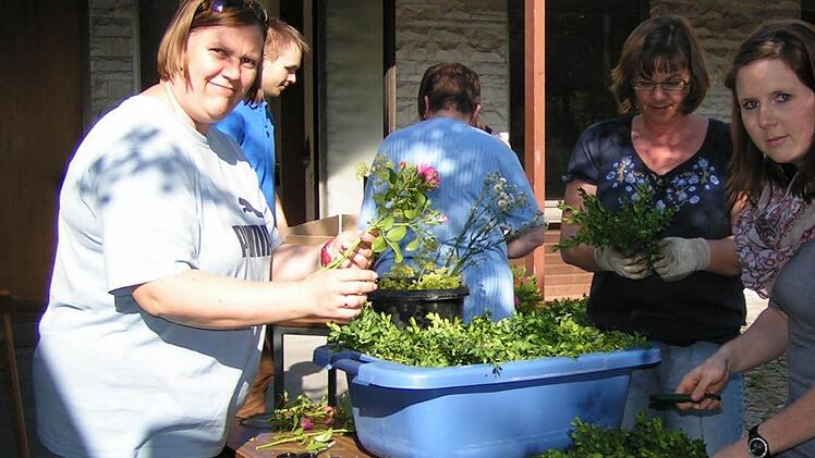 Anna Hack, Doris Reichel und Alexandra Krause (v.l.) schneiden Buchszweige für die Girlanden.  Foto: Amon
