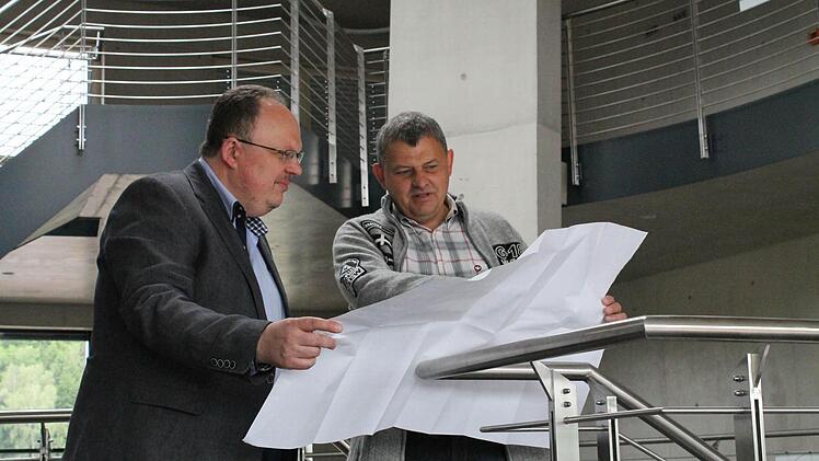 Fast fertig: Peter Dechant (links) und sein Bruder Thomas werfen einen Blick auf die Baupläne des neuen Bürogebäudes. Foto: Thomas Heuchling