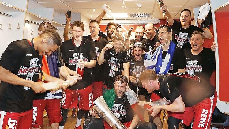 Nicolo Melli hält die Meistertrophäe in Händen - die Brose-Spieler feiern in der Kabine ausgelassen den Triumph.  Fotos: Daniel Löb