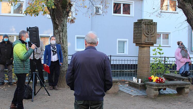 Am Synagogendenkmal begr&uuml;&szlig;te Emmerich Huber die Teilnehmer der Gedenkveranstaltung.  Am Denkmal selbst konnten Blumen niedergelegt und Kerzen angez&uuml;ndet werden.  Foto: Vera Schiller