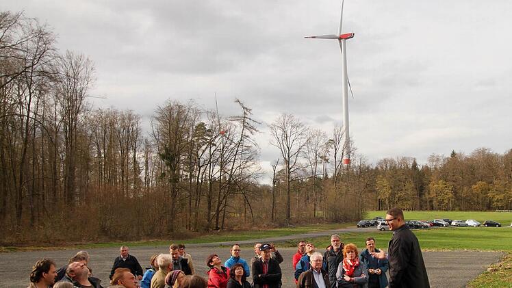 Projektingenieur Markus Eichhorn (rechts) informierte die Mitglieder, hier vor dem Windrad 1, im Hintergrund weitere Windräder. Fotos: Günther Geiling