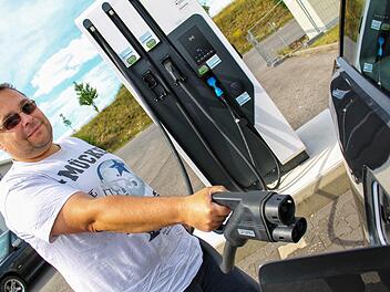 Jürgen Frey tankt sein Elektrofahrzeug an der Ladestation auf dem Haßfurter Norma-Parkplatz auf. Wie viel das Akkuladen am Ende kostet, ist bei vielen Ladestationen aber vorher nicht ersichtlich. Foto: Teresa Hirschberg