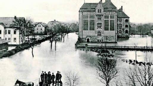 Beim Lauter-Hochwasser am 4. Februar 1909 konnte der Fluss ungehindert über die Ufer treten. Die Heilig-Kreuz-Schule (rechts) war nicht mehr trockenen Fußes zu erreichen. Postkarte: Verlag August Hermann