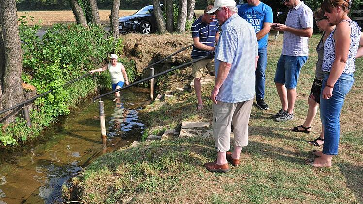 Der Bau- und Umweltausschuss Wonfurt (im Bild) beschloss, das Wassertretbecken an der Roten Quelle in Wonfurt aufzuwerten. Mit im Bild Elisabeth Schweinitzer, die die Altachquelle regelmäßig zum Wassertreten nutzt. Foto: Ulrike Langer