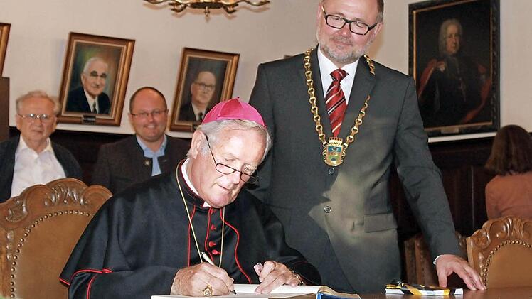 Eintrag ins Goldene Buch: "Früher hieß es, Kinder seid still, Vater schreibt seinen Namen", witzelte der Bischof angesichts der andächtigen Stille im kleinen Sitzungssaal.
