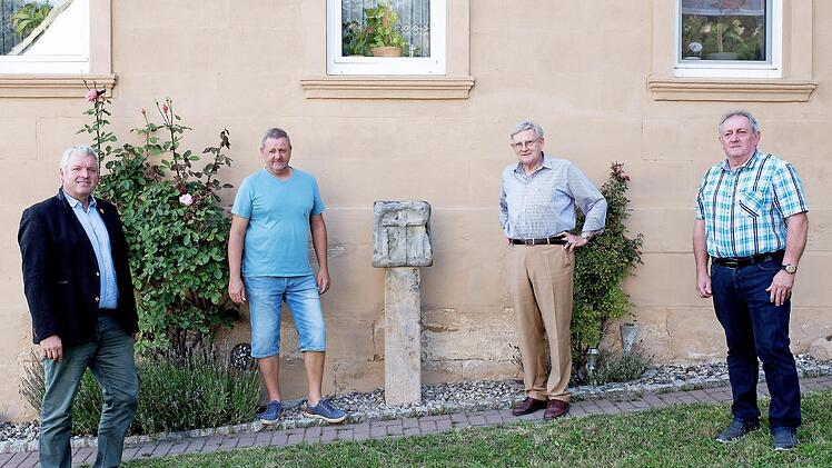Der Bildstock zeigt an der einen Seite Maria und Johannes unter dem Kreuz und auf den anderen Seiten Petrus und Paulus sowie den heiligen Andreas. Neben dem Bildstock stehen, von links: Bürgermeister Jürgen Hennemann, Steinmetz Thomas Groh, Kreisheimatpfleger Günter Lipp und Alfred Dorsch vor dem Anwesen Dorsch in Fierst.  Foto: Michaela Mogath