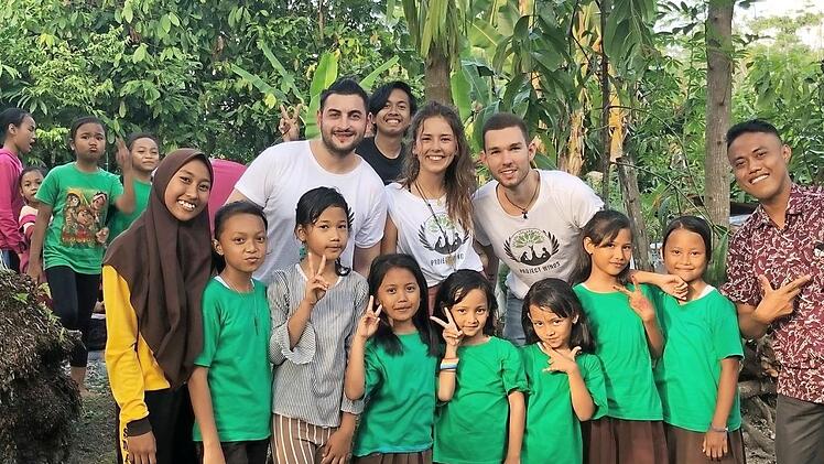 Erich Stieb, Leonie Deimann und Marc Helwing inmitten von Bewohnern des Dorfes Bukit Lawang und Schülern der Green Class, die  Umweltprobleme gemeinsam zu lösen versuchen.