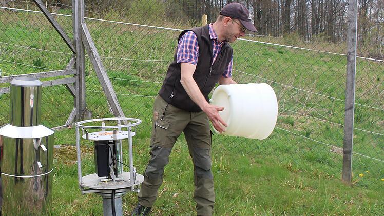 Michael Schneider leert die Wasserwaage aus. Von hier aus wird der Niederschlag direkt nach Freising gemeldet. Foto: Julia Raab