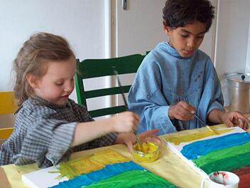 Gemeinsam kreativ: Paula und Ahmed malen konzentriert im Atelier von Simone Mahler. Foto: Bauer