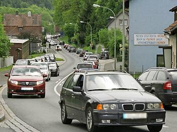 "Müssen erst Reifen brennen, bevor die Politiker unser Verkehrsproblem erkennen?" steht an einem Haus in Kauerndorf. Indem sie vier Autos und Traktoren geschickt am Straßenrand parkt, verursachten Bürger gestern Nachmittag in dem Ködnitzer Ortsteil einen riesigen Stau. Fotos: Sonja Adam