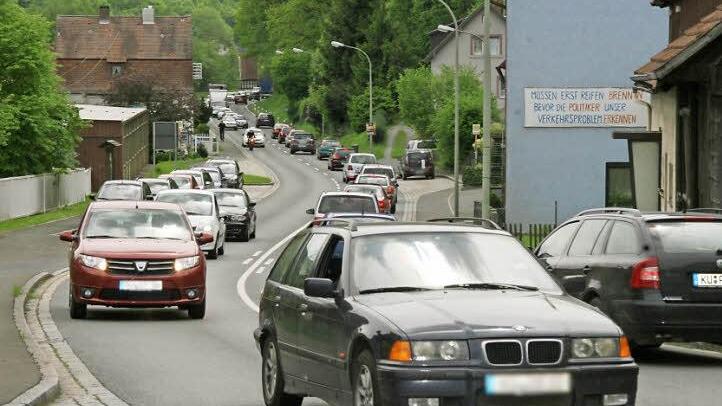 "Müssen erst Reifen brennen, bevor die Politiker unser Verkehrsproblem erkennen?" steht an einem Haus in Kauerndorf. Indem sie vier Autos und Traktoren geschickt am Straßenrand parkt, verursachten Bürger gestern Nachmittag in dem Ködnitzer Ortsteil einen riesigen Stau. Fotos: Sonja Adam